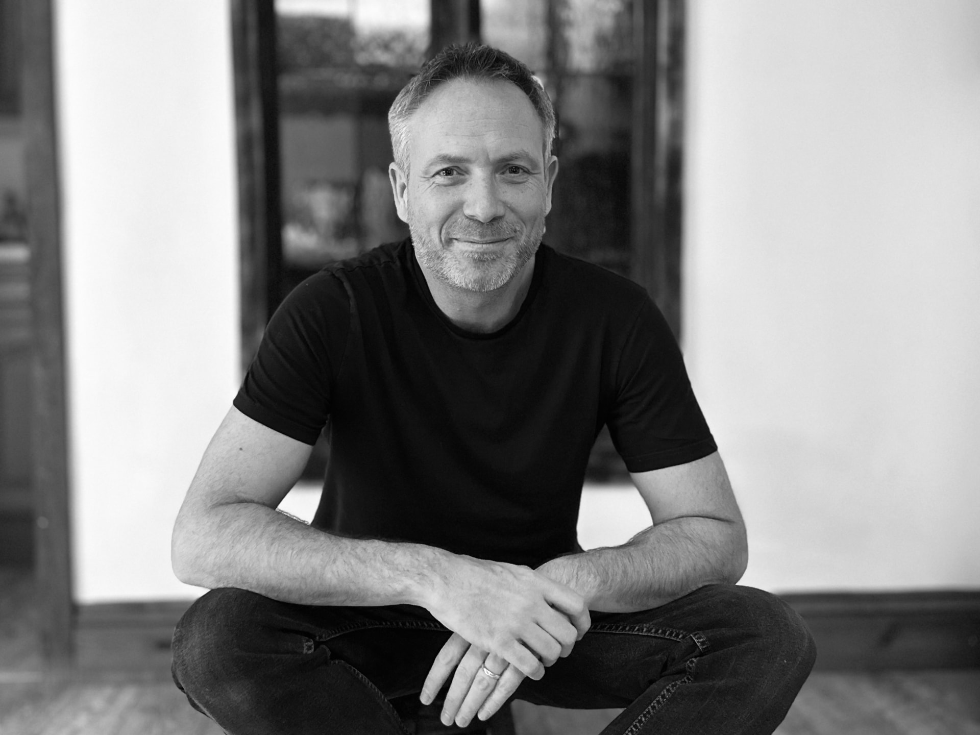 Portrait of Ross Anderson, seated, wearing a black t-shirt